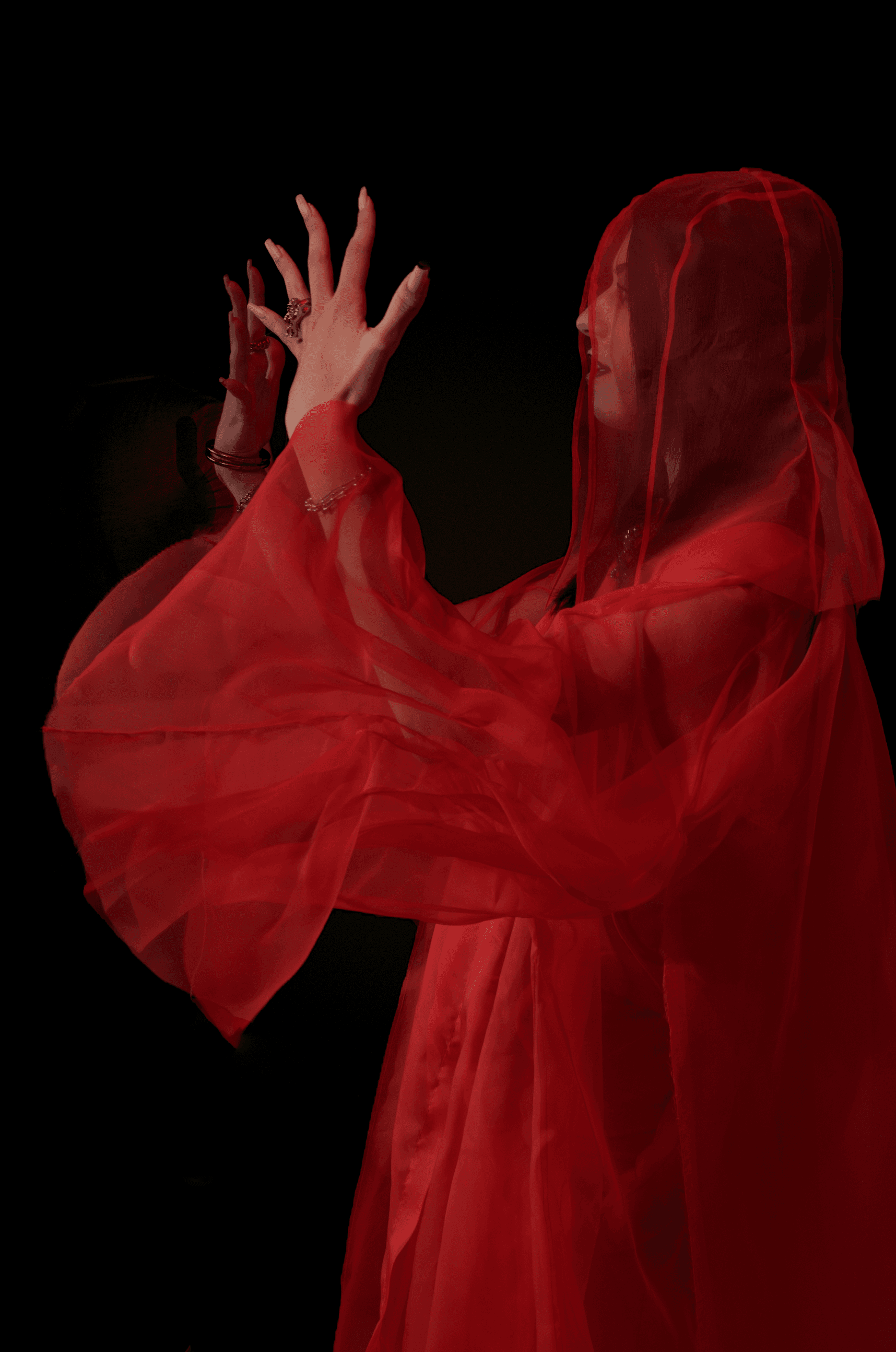 Figure veiled in translucent red fabric